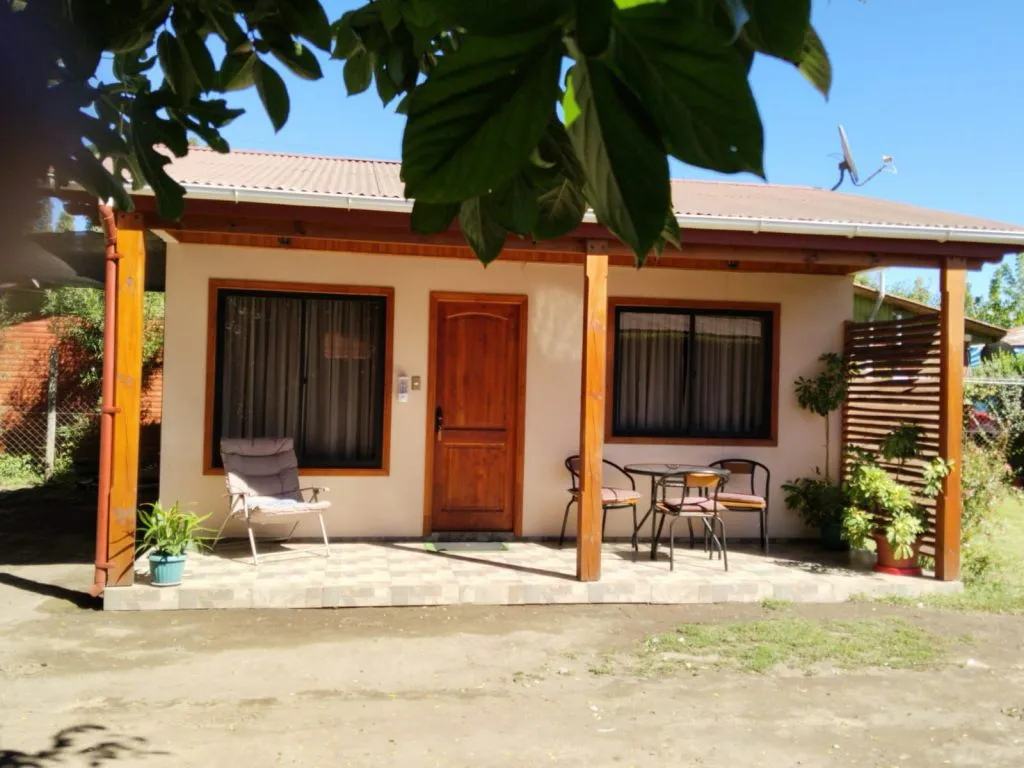 Living con comedor, TV y sofás en cabaña de madera de Cabañas Fabi