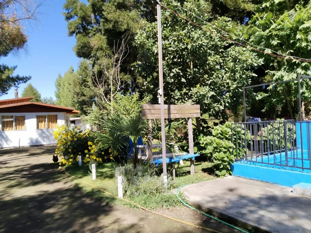 Habitación con cama y TV en pared de madera en Cabañas Fabi Salto del Laja